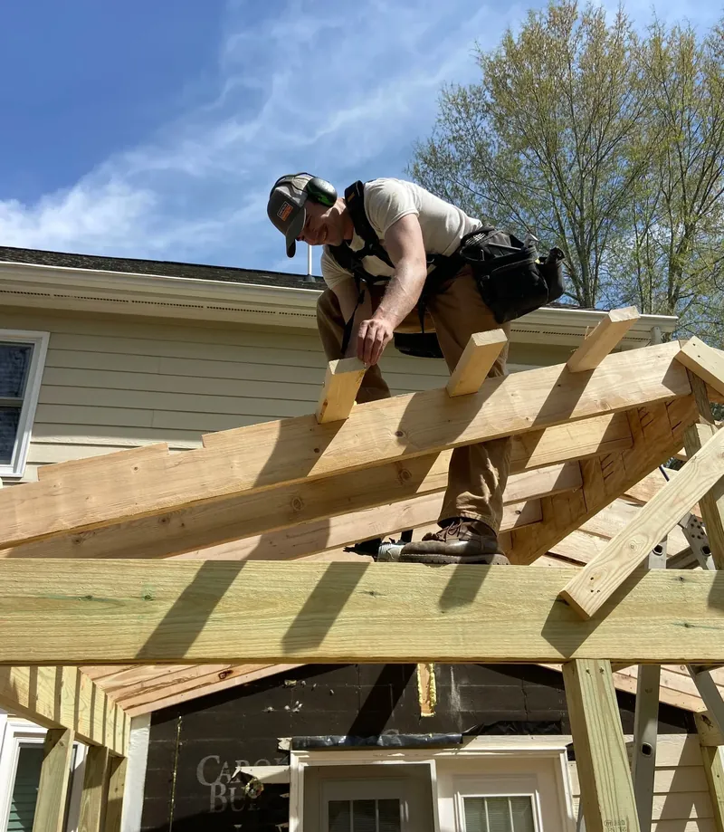 Bright Ridge Construction crew member framing the roof structure of a new porch